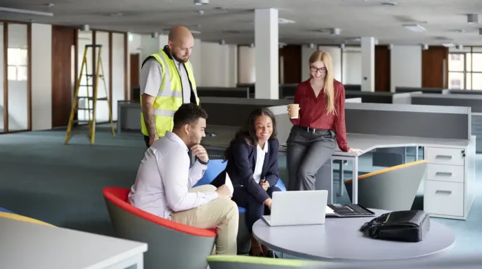 Commercial property landlords looking at net effective rent calculator on computer in empty office space. 