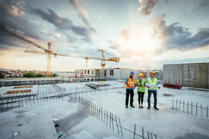 Three commercial developers on-site at premises, with laptop and notepads in hand.