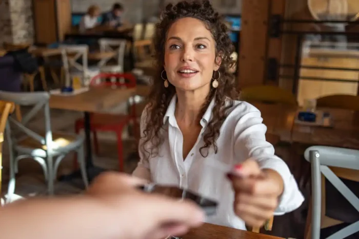 Confident consumer paying for coffee in a cafe in Australia.